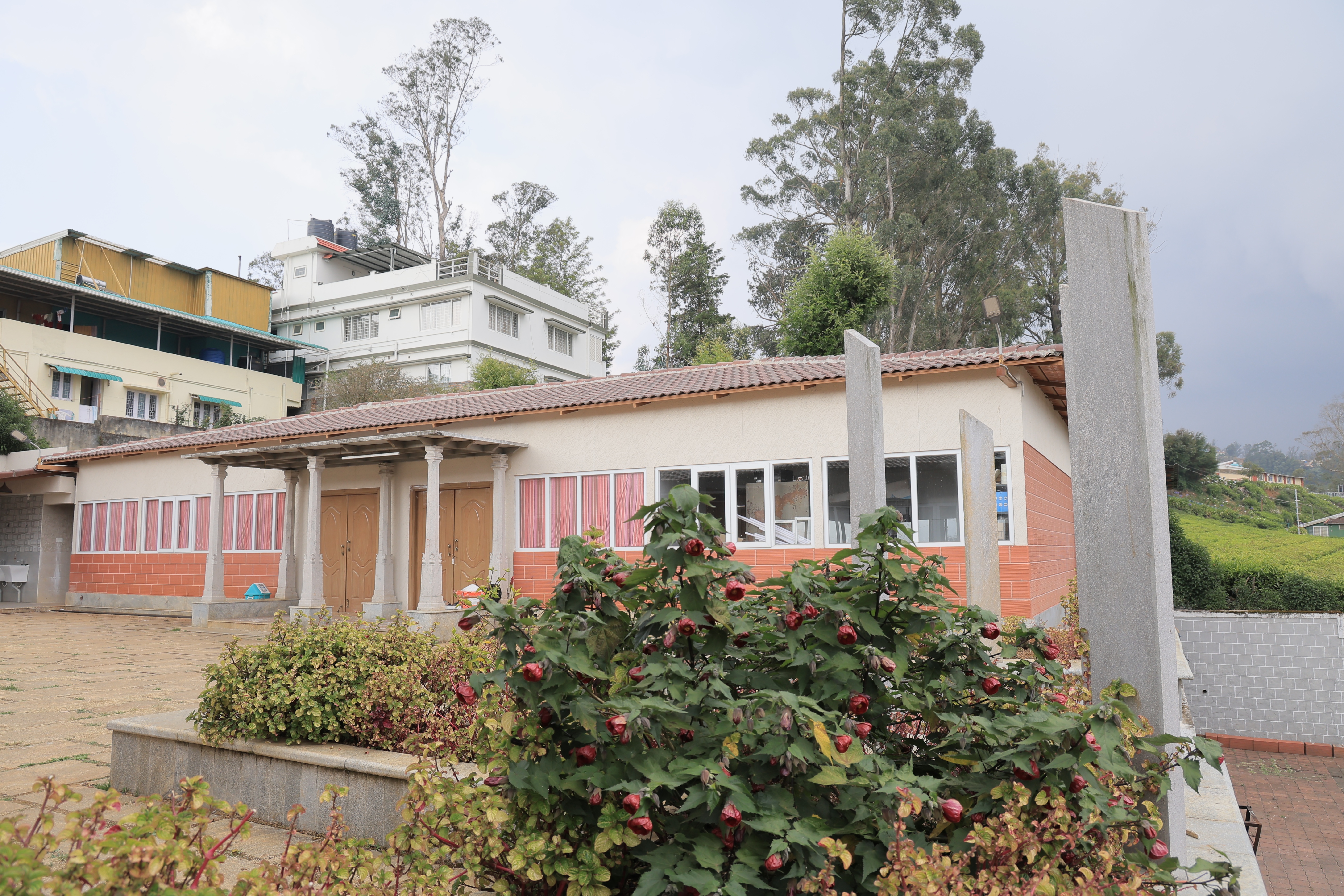 Exterior view of LMS Palve Sugavasam Ooty featuring modern architecture, landscaped gardens, and peaceful hillside surroundings.