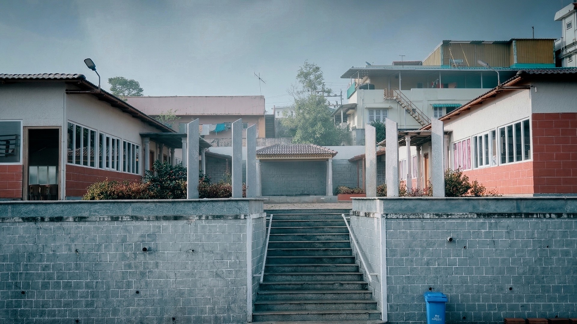 Elegant hotel exterior featuring symmetrical architecture, red tiled roof, and welcoming entrance walkway 