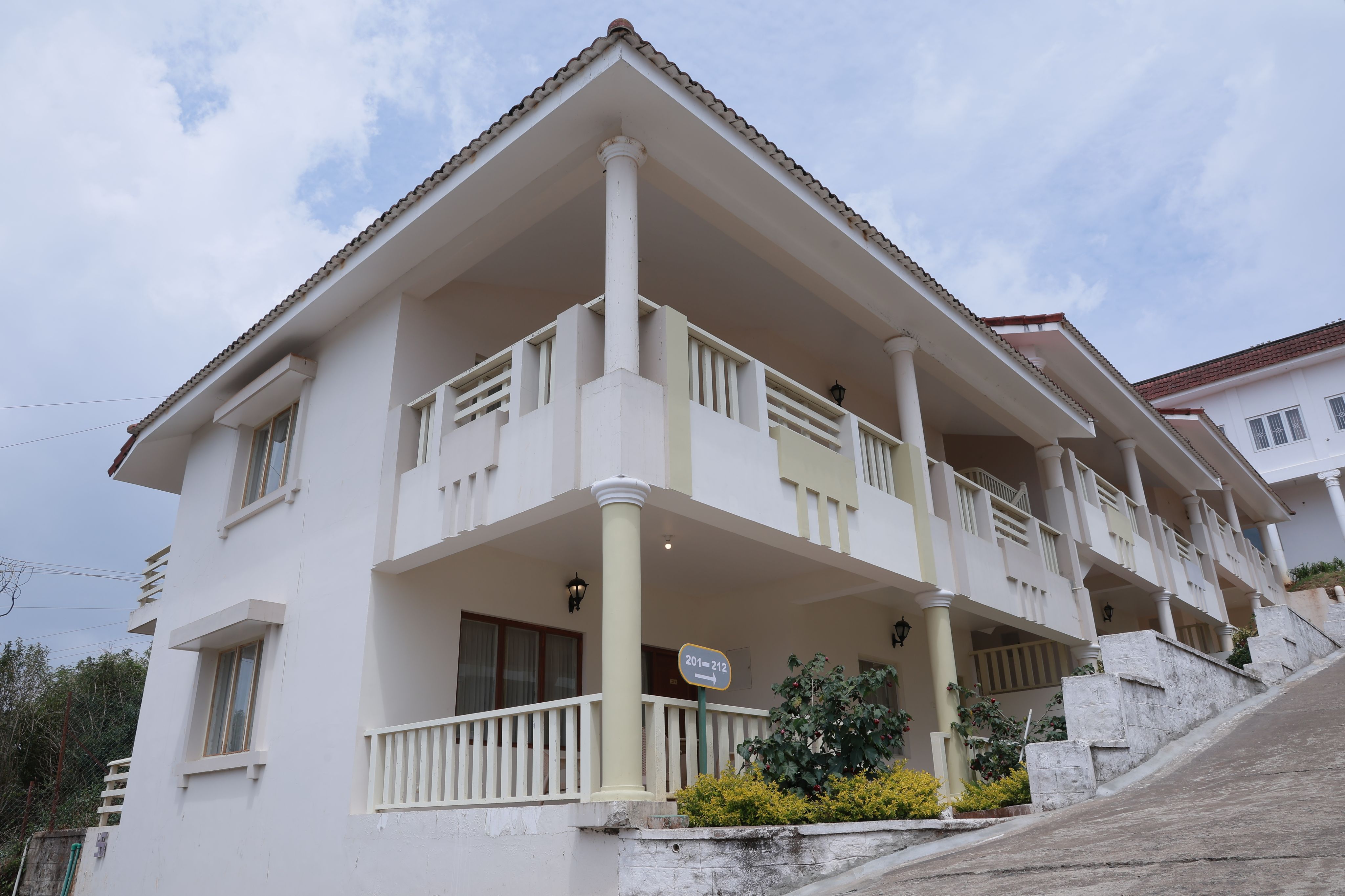 Luxury hillside resort with balcony rooms, modern architecture, and scenic mountain views. 