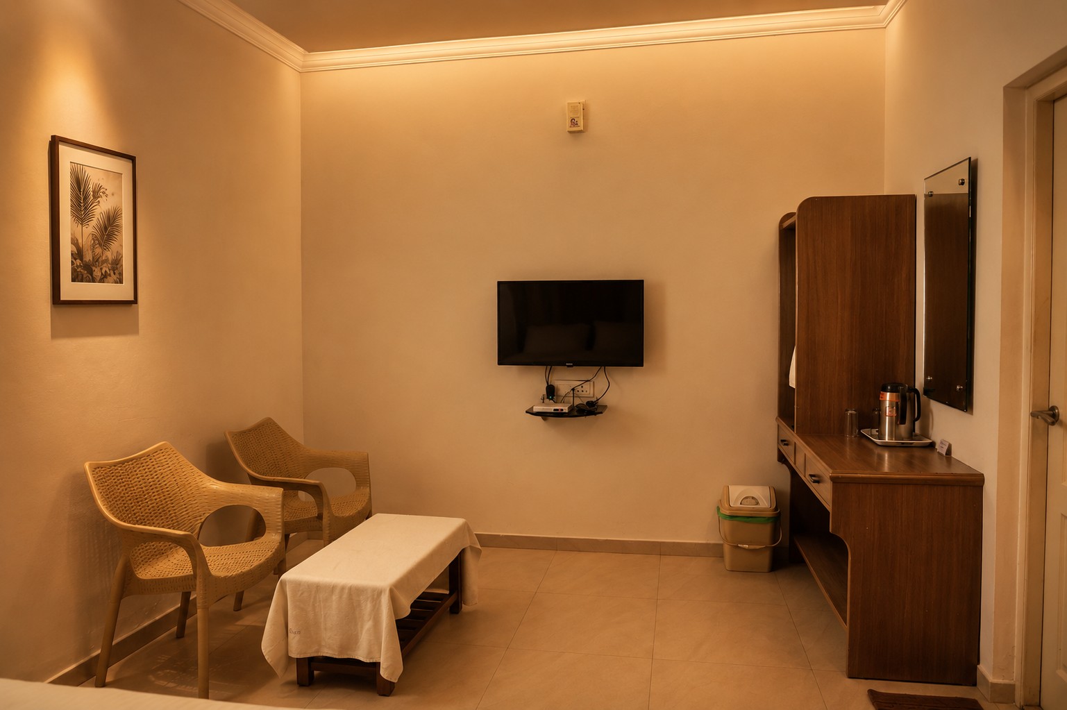 Spacious luxury hotel room with comfortable seating area, smart TV, coffee station, and modern interiors